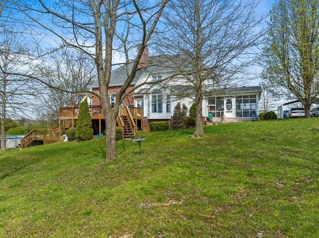 back of property with a wooden deck and a yard