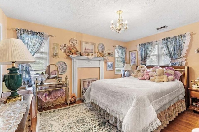 bedroom featuring multiple windows, a textured ceiling, and light wood-type flooring