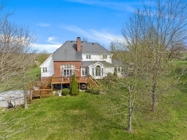 back of property featuring a deck and a yard