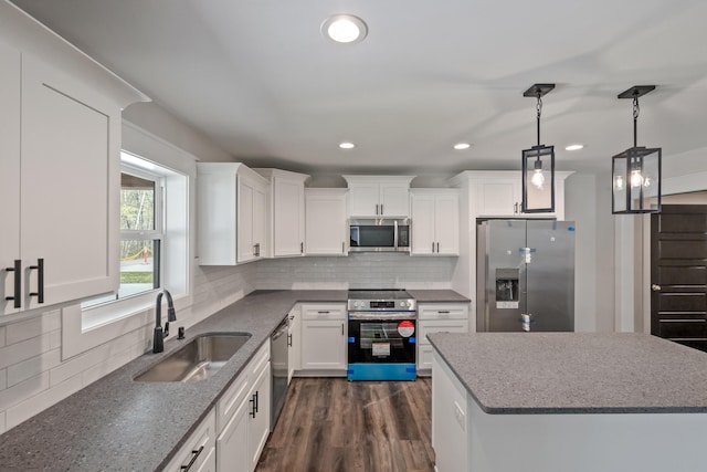 kitchen featuring white cabinets, dark wood-type flooring, stainless steel appliances, sink, and tasteful backsplash