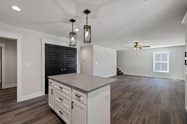 kitchen featuring white cabinets, ceiling fan, a kitchen island, and dark hardwood / wood-style flooring