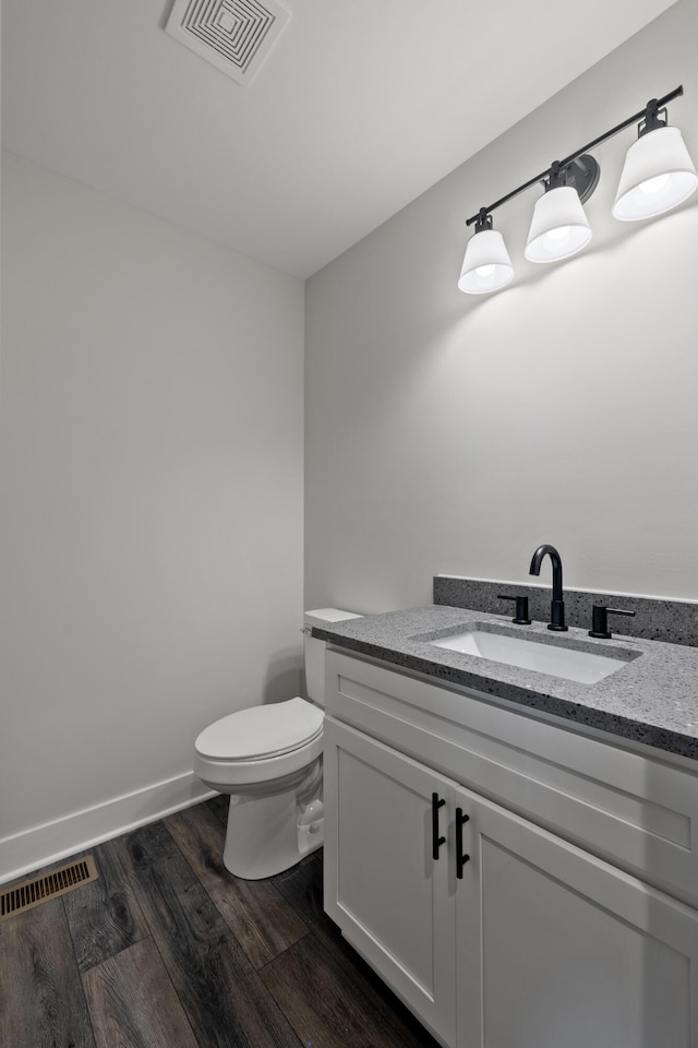 bathroom featuring wood-type flooring, vanity, and toilet