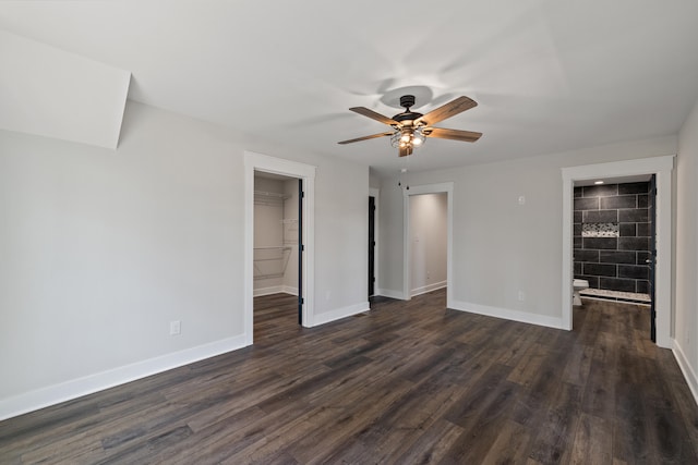 unfurnished bedroom featuring a spacious closet, connected bathroom, ceiling fan, and dark hardwood / wood-style floors