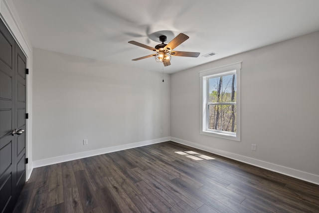 spare room with dark hardwood / wood-style flooring and ceiling fan