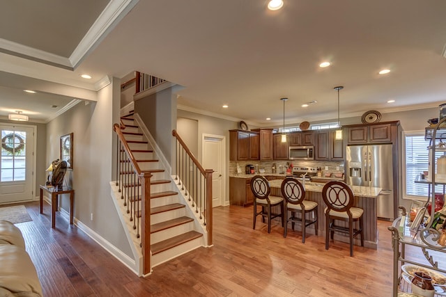 kitchen with decorative light fixtures, a kitchen island, hardwood / wood-style flooring, and stainless steel appliances