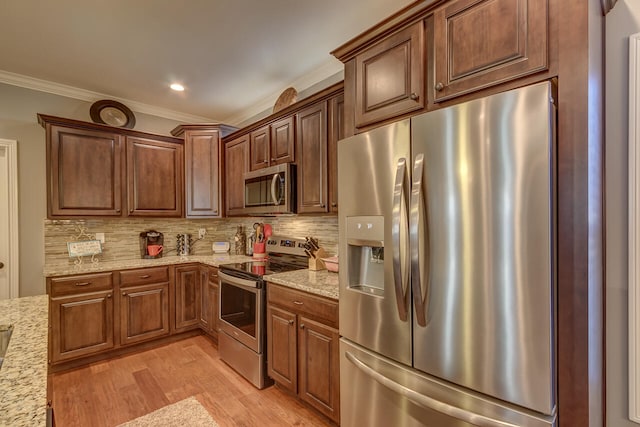 kitchen featuring appliances with stainless steel finishes, backsplash, light hardwood / wood-style floors, light stone counters, and ornamental molding