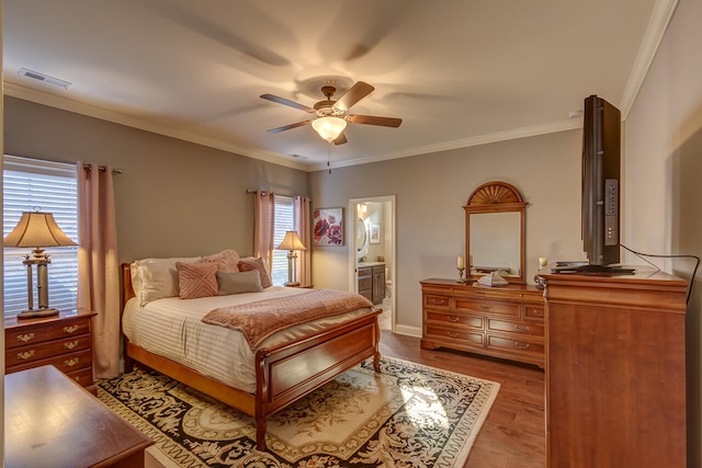 bedroom featuring ceiling fan, ensuite bathroom, dark hardwood / wood-style flooring, and ornamental molding