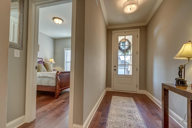 foyer entrance with crown molding and dark hardwood / wood-style floors