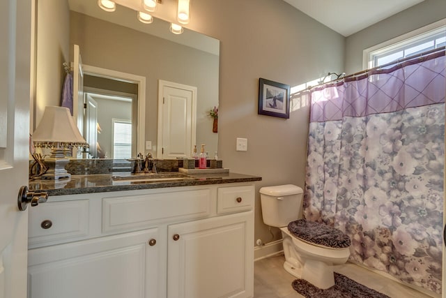 bathroom featuring vanity, toilet, and tile flooring