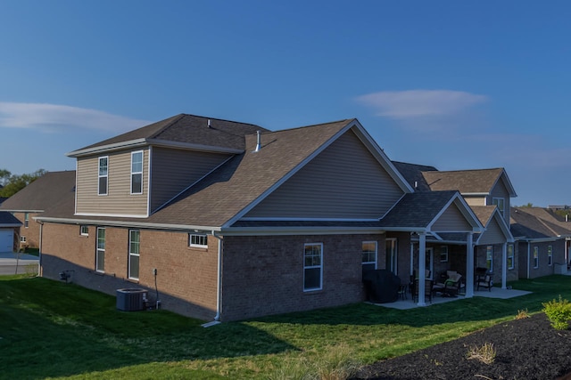 rear view of property featuring central air condition unit, a patio, and a lawn