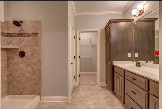 bathroom featuring tiled shower, oversized vanity, crown molding, and tile floors