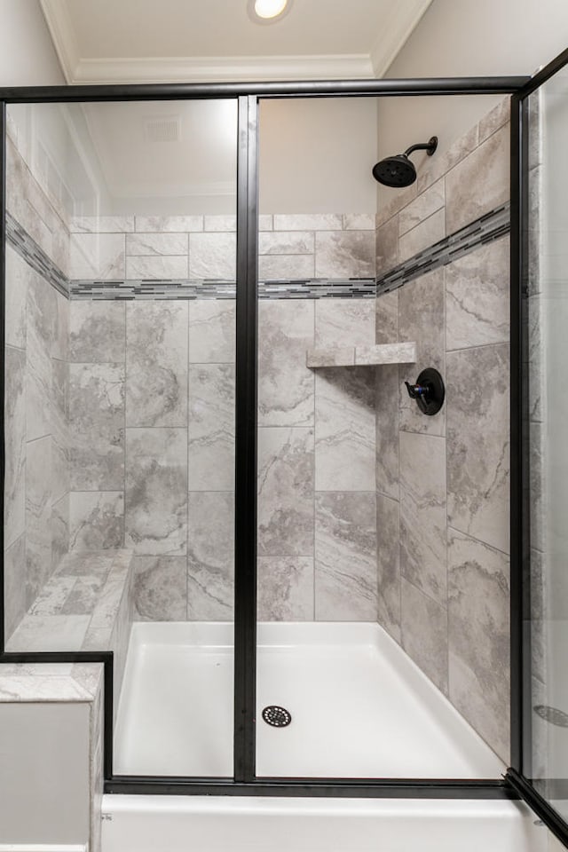 bathroom featuring a shower with door and crown molding