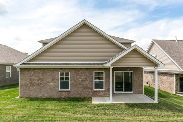 rear view of house with a patio and a lawn