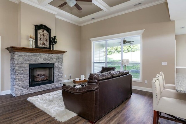 living room with a stone fireplace, dark hardwood / wood-style floors, ceiling fan, ornamental molding, and coffered ceiling