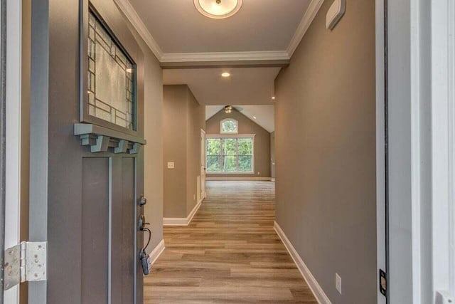 corridor featuring light hardwood / wood-style floors, ornamental molding, and lofted ceiling