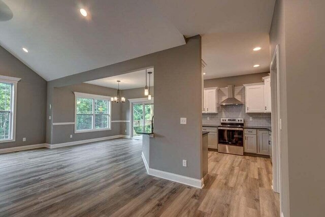 313 Old Station Rd, Frankfort, KY 40601 - kitchen featuring tasteful backsplash, a chandelier, stainless steel range with electric cooktop, light wood-style floors, and wall chimney exhaust hood