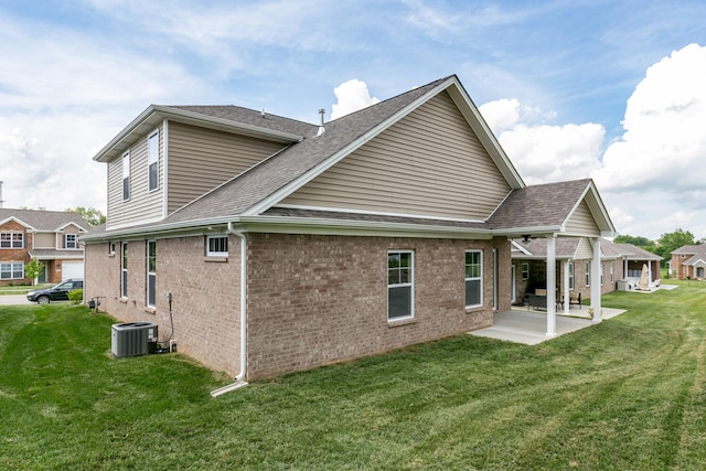 back of property with central AC, a yard, and a patio area