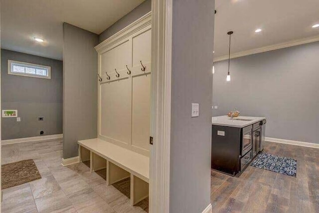 mudroom featuring light hardwood / wood-style flooring, sink, and crown molding