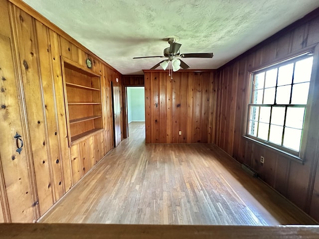 256 Carrick Pike, Georgetown, KY 40324 - empty room featuring hardwood / wood-style floors, wooden walls, ceiling fan, a textured ceiling, and built in features