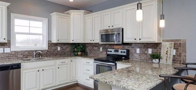 kitchen with white cabinets, hanging light fixtures, and stainless steel appliances