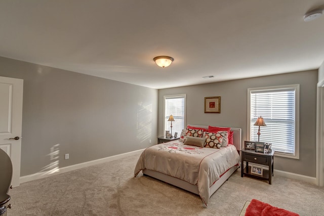 bedroom featuring light carpet and multiple windows