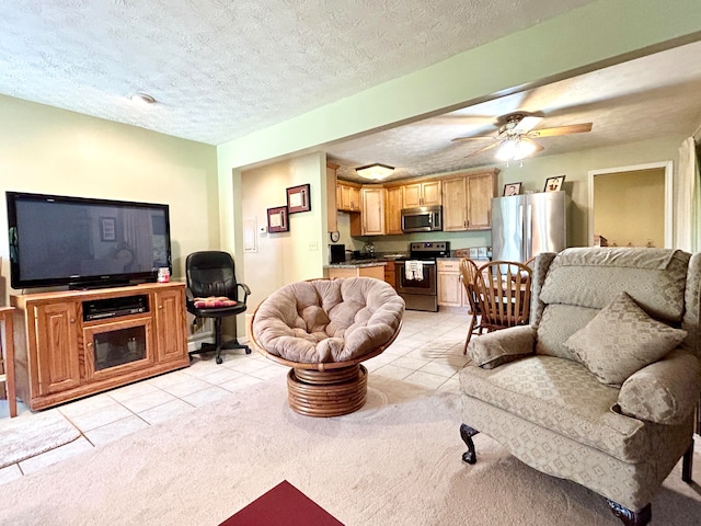 carpeted living room featuring ceiling fan and a textured ceiling