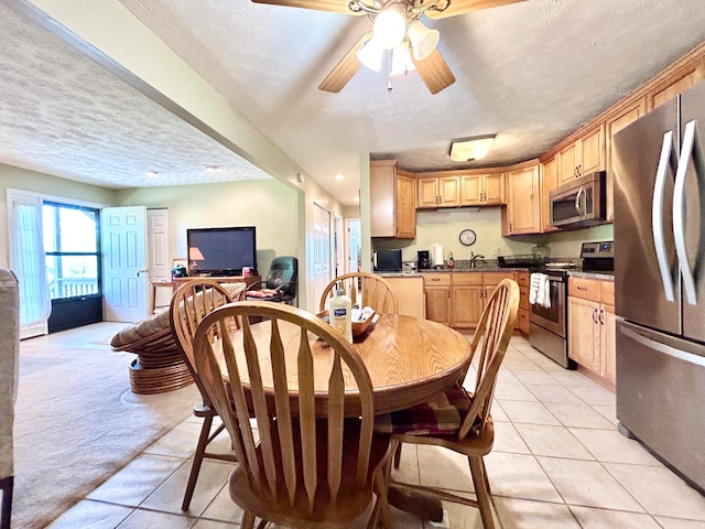 tiled dining room featuring ceiling fan and a textured ceiling