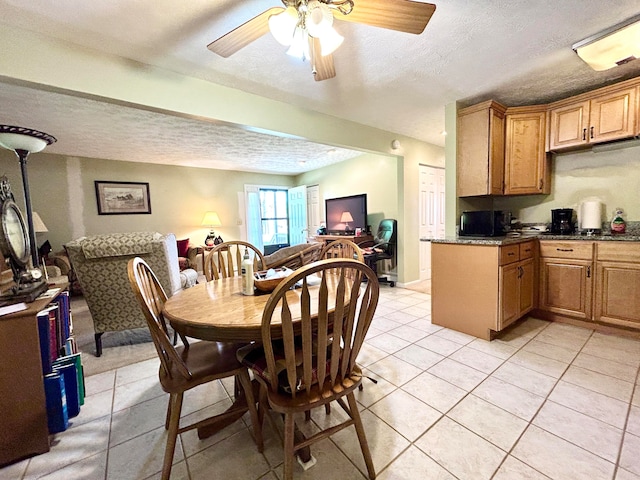 tiled dining area featuring ceiling fan and a textured ceiling