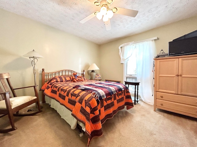 carpeted bedroom with ceiling fan and a textured ceiling