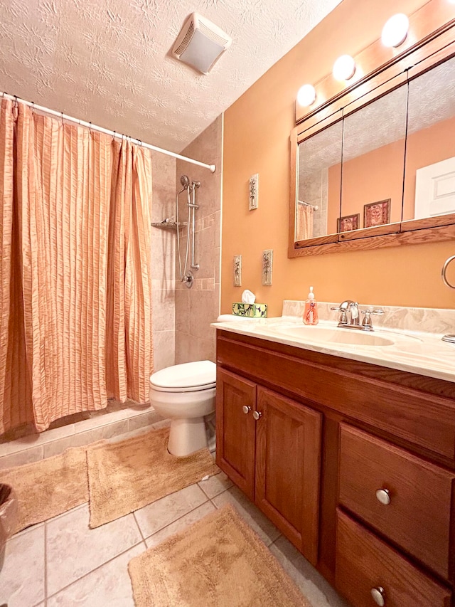 bathroom with toilet, tile flooring, vanity, and a textured ceiling