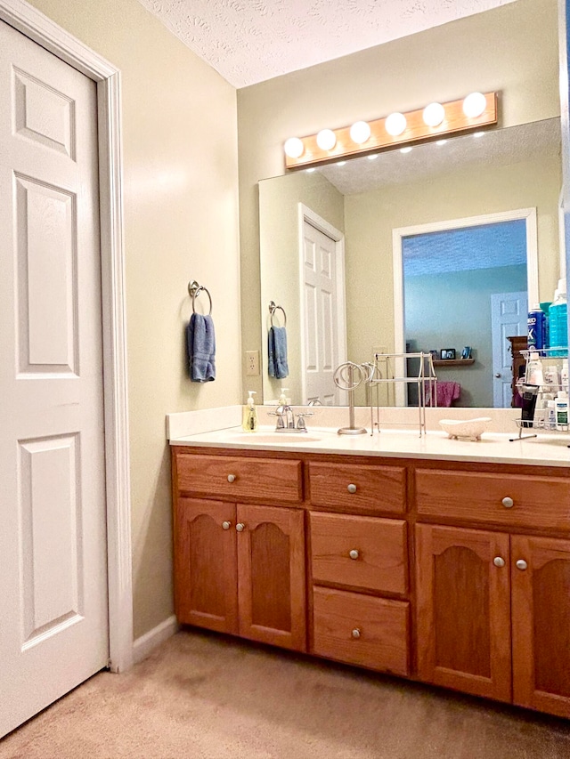 bathroom with dual vanity and a textured ceiling