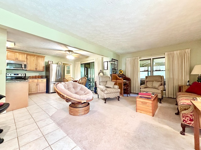 living room with light tile floors, ceiling fan, and a textured ceiling