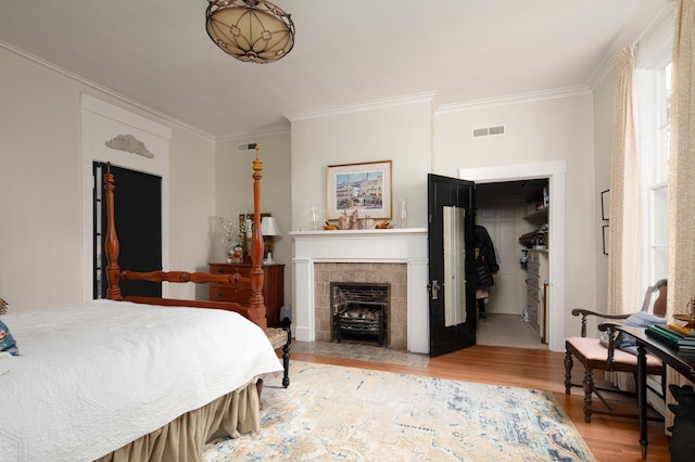 511 Boone Ave, Winchester, KY 40391 - bedroom with ornamental molding, a closet, light hardwood / wood-style flooring, and a tiled fireplace
