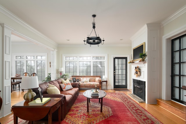 living room featuring light hardwood / wood-style floors, crown molding, plenty of natural light, and a premium fireplace