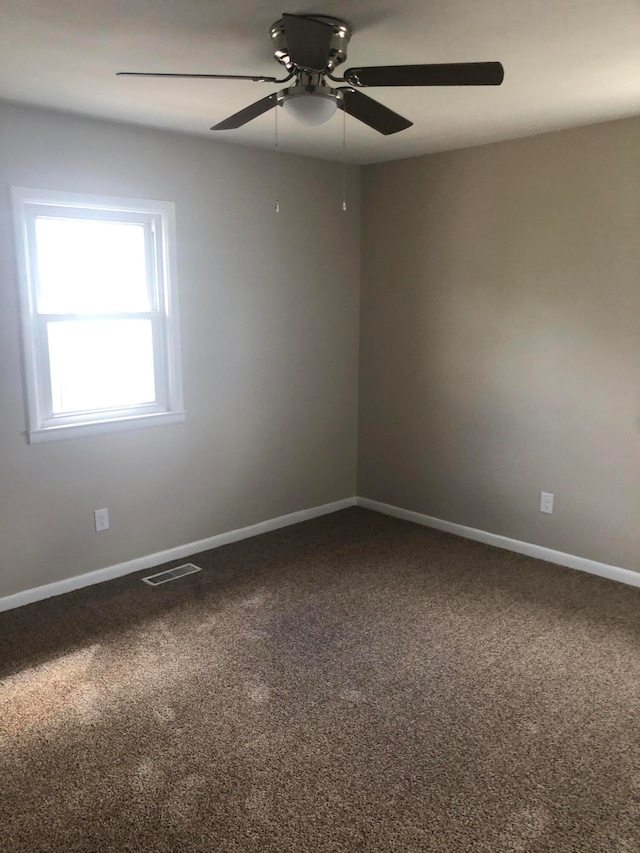 spare room featuring ceiling fan and carpet