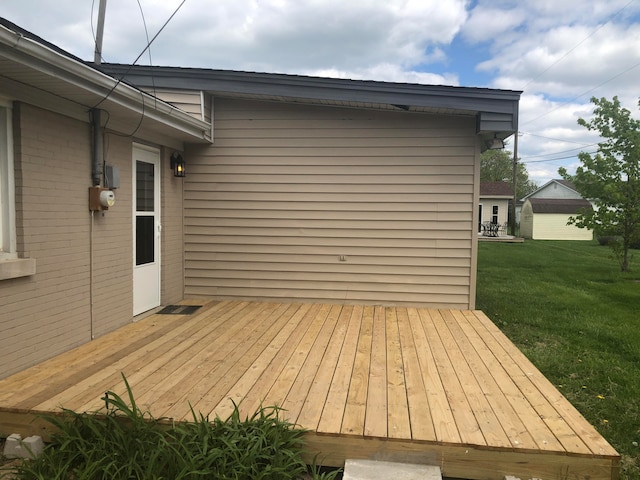 wooden terrace featuring a lawn