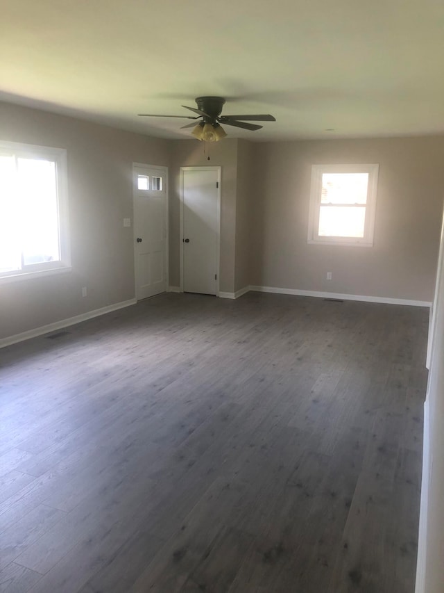 spare room featuring ceiling fan, plenty of natural light, and dark hardwood / wood-style flooring