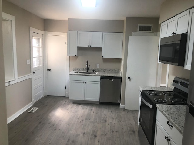 kitchen featuring appliances with stainless steel finishes, sink, light wood-type flooring, and white cabinetry