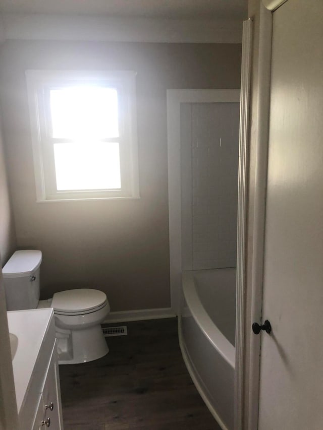 full bathroom featuring wood-type flooring, shower / bath combination, vanity, and toilet