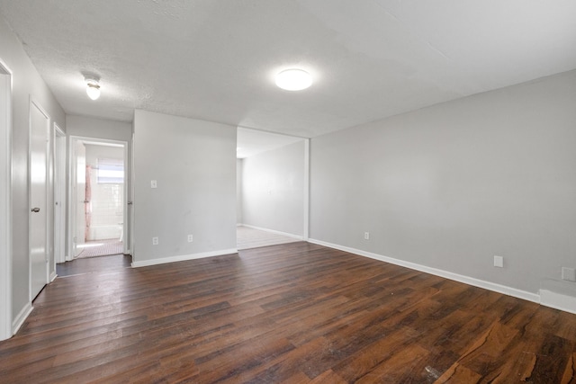 spare room with dark hardwood / wood-style flooring and a textured ceiling