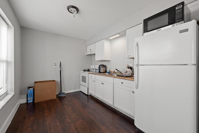 kitchen with plenty of natural light, white cabinets, dark hardwood / wood-style floors, and white appliances