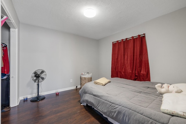 bedroom with dark wood-type flooring and a textured ceiling