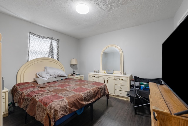 bedroom with a textured ceiling and dark hardwood / wood-style flooring