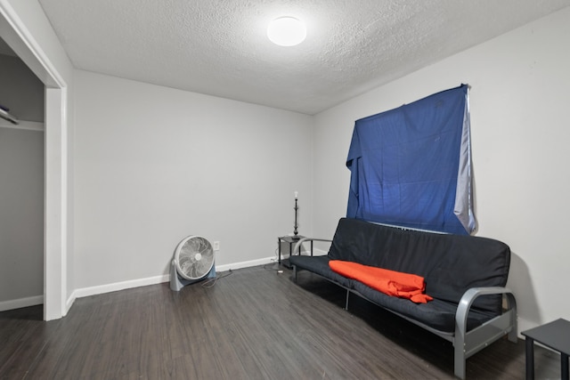 sitting room with dark hardwood / wood-style flooring and a textured ceiling