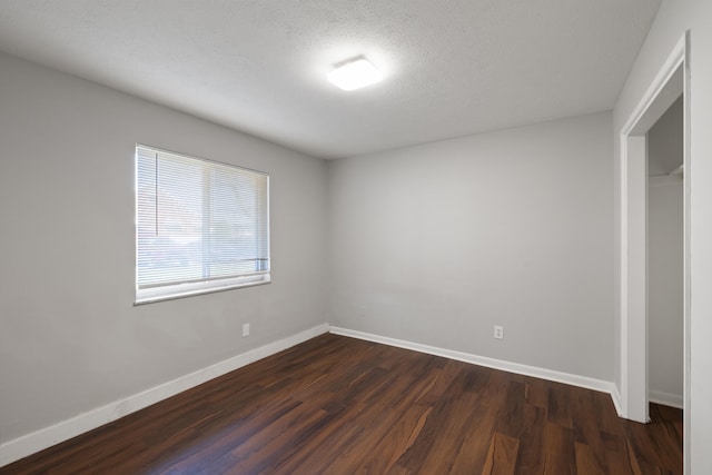 unfurnished bedroom featuring dark hardwood / wood-style flooring and a textured ceiling