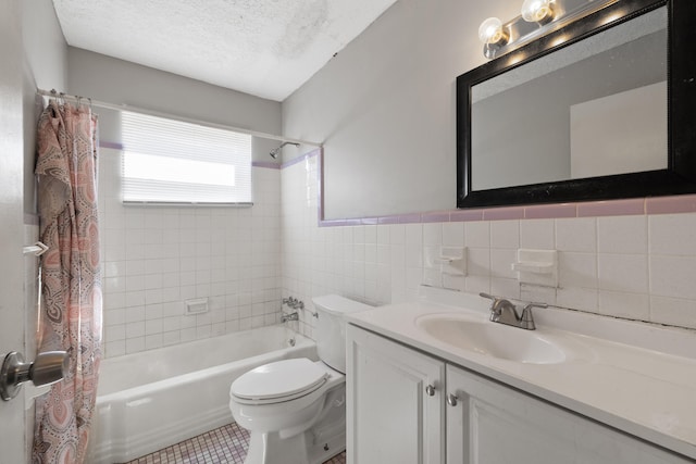 full bathroom with shower / bath combo, tile patterned floors, vanity, a textured ceiling, and tile walls