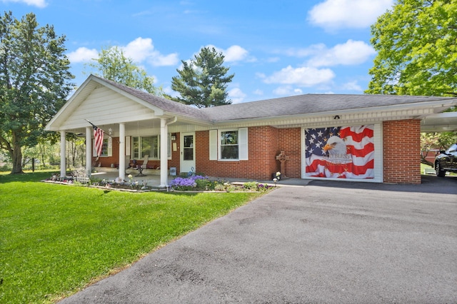 ranch-style house with a front lawn, a carport, and a porch