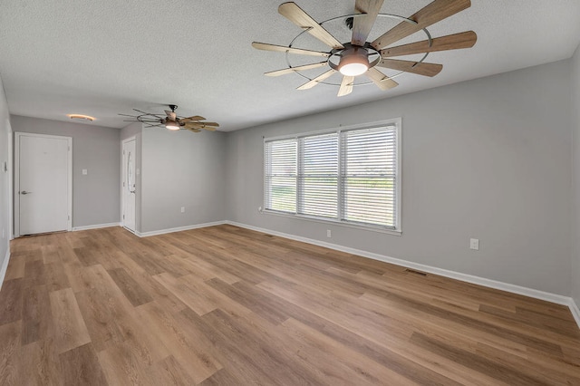 empty room with wood-type flooring, ceiling fan, and a textured ceiling