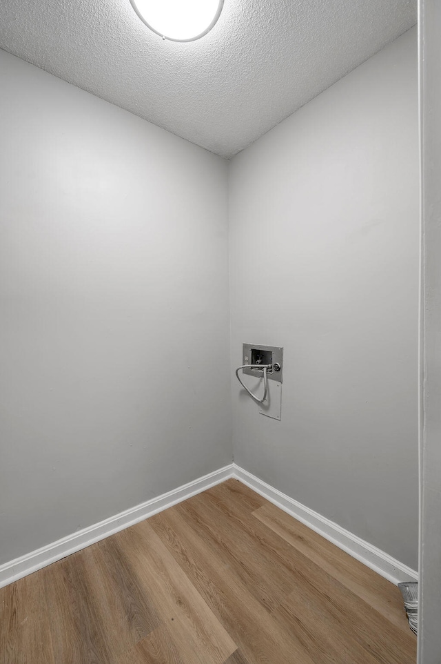 laundry area featuring hardwood / wood-style flooring, hookup for a washing machine, and a textured ceiling