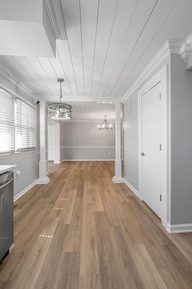 interior space featuring light hardwood / wood-style flooring, decorative columns, crown molding, and an inviting chandelier